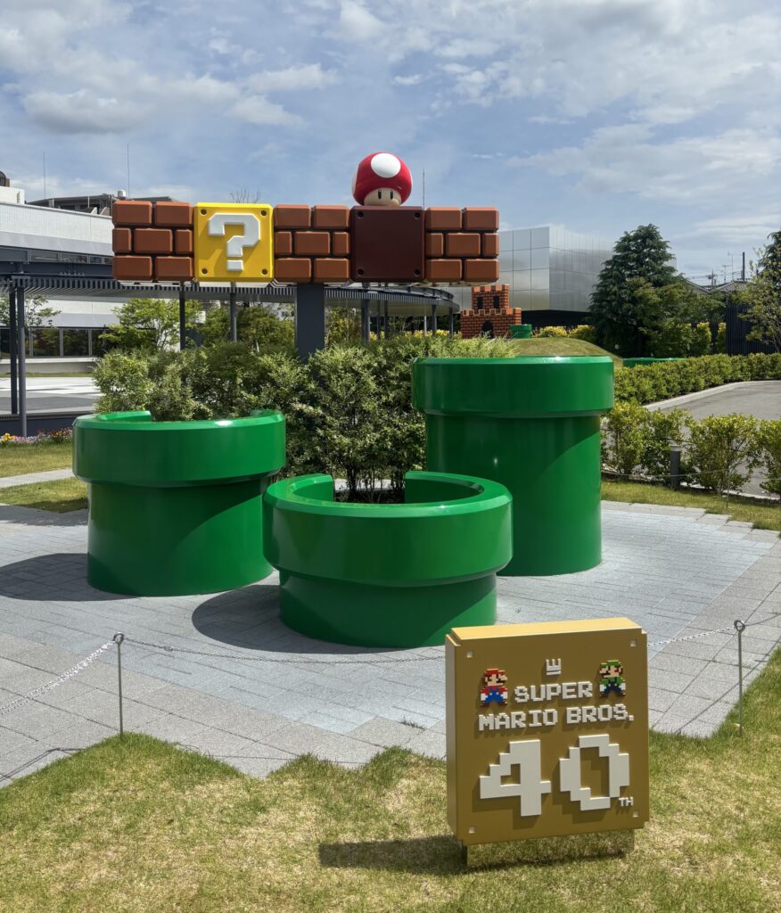 ニンテンドーミュージアムの屋外にある、スーパーマリオブラザーズ40周年ロゴと土管、ハテナブロックが再現された記念撮影スポット